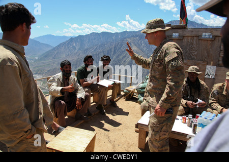 Un soldat de l'armée américaine enseigne l'anglais aux membres de la garde de sécurité afghanes pendant un cours de langue sur le poste d'observation Mustang le 3 mai 2012 dans la province de Kunar, Afghanistan. La classe de langue est un événement quotidien qui développe un lien plus fort entre l'ASG et les soldats de l'armée US. Banque D'Images