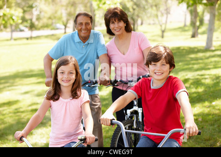 Hispanic family riding bikes in park Banque D'Images