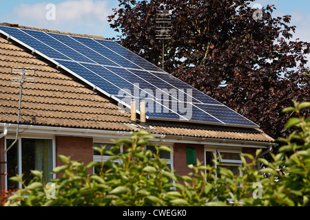 Panneaux solaires photovoltaïques montés sur un toit de tuiles de l'immeuble ou maison privée Banque D'Images