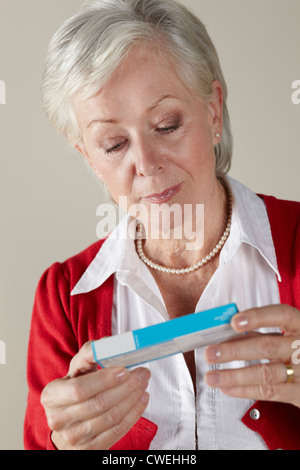 Senior woman looking at prescription drug pack Banque D'Images