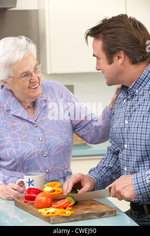 Mère et fils adultes la préparation de repas ensemble Banque D'Images