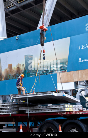 Nouveau bâtiment en construction dans la ville de Londres avec la supervision des travailleurs de matériaux de levage par grue jusqu'au niveau supérieur Banque D'Images