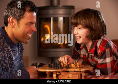 Père et fils jouant aux échecs par Cheminée Banque D'Images