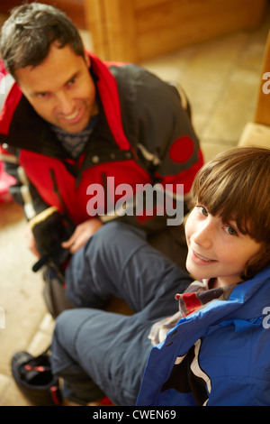 Père Fils aidant à mettre sur les vêtements et chaussures de plein air chaud Banque D'Images