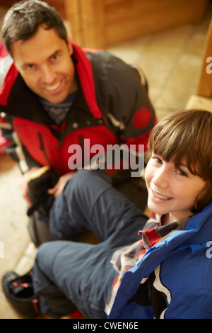 Père Fils aidant à mettre sur les vêtements et chaussures de plein air chaud Banque D'Images