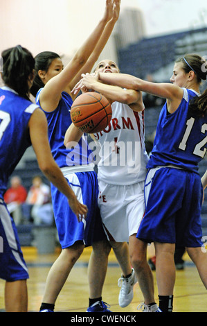 A la balle de basket-ball de sa compréhension en pot comme elle est encrassée tente de diviser la défense. USA. Banque D'Images