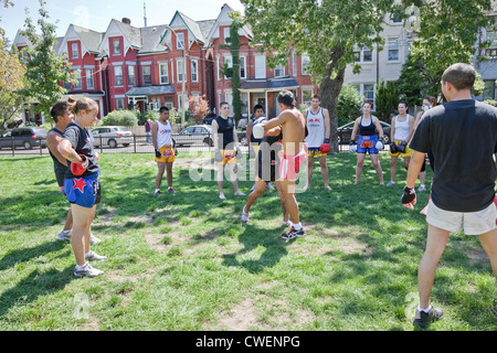 Un groupe de jeunes hommes et femmes pratiquent à l'extérieur dans un parc de la ville ou de Muay Thai Boxe Arts Martiaux dans Toronto;Ontario;Canada Banque D'Images