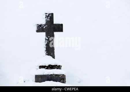 Pierre tombale en forme de croix, la vallée du cimetière, Stirling, Ecosse, Royaume-Uni. Hiver neige Banque D'Images