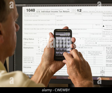 L'impôt électronique formulaire 1040 pour 2012 pour nous les retourner à l'écran avec calculatrice smartphone Banque D'Images