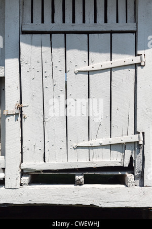 Porte de grange en bois peint en blanc et usés et pourrissaient