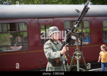 Soldat allemand sur un quai de gare à l'arme lourde Banque D'Images