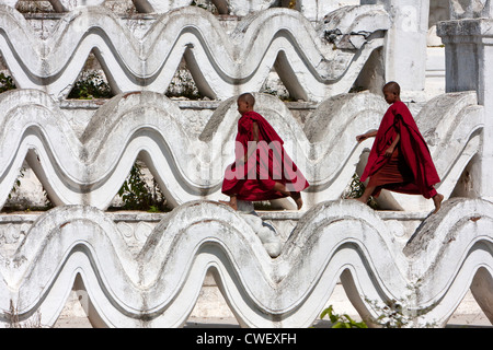 Le Myanmar, Birmanie. Mingun, près de Mandalay. Deux jeunes moines bouddhistes débutants marche sur l'Hsinbyume Paya, un stupa construit en 1816. Banque D'Images