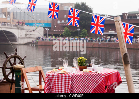 Popping le bouchon sur une bouteille de champagne de fête, juste à temps pour la Barge Royale Gloriana, de passer par Kingston Bridge. Banque D'Images