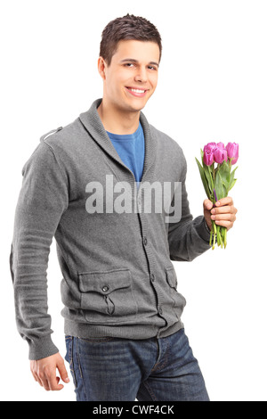 Handsome young man holding tulipes isolés contre fond blanc Banque D'Images