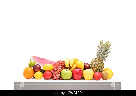 Pile de fruits sur une table contre isolé sur fond blanc Banque D'Images