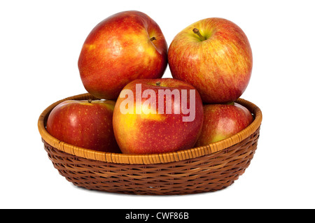 Pommes rouges et jaunes dans le panier en bois sur fond blanc Banque D'Images