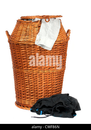 Panier à linge en osier ou d'entraver la pleine de vêtements sales sur fond blanc Banque D'Images