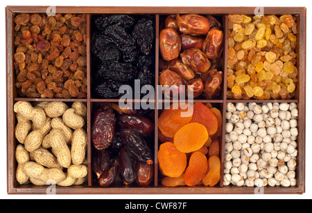 Un assortiment de fruits secs en boîte bois,isolé sur fond blanc.Raisin,prune,date,monkey-écrou, abricot, noix Banque D'Images