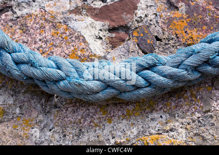 Vieille corde accrochée à un mur du port. Banque D'Images