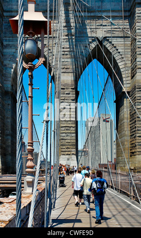 NEW YORK - 31 MAI 2009 : Les personnes marchant sur le pont de Brooklyn à New York. Manhattan est à l'arrière-plan. Banque D'Images