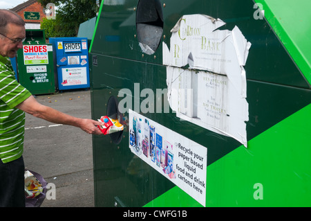 Un homme d'un recyclage carton Tropicana à une banque de recyclage à Littlehampton, Shropshire, Angleterre Banque D'Images