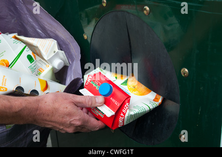 Un homme d'un recyclage carton Tropicana à une banque de recyclage à Littlehampton, Shropshire, Angleterre Banque D'Images