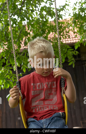 Blonde Enfant Garçon jouant avec un jardin d'été Banque D'Images