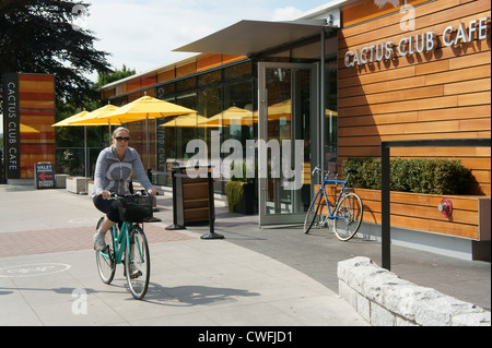 Cycliste féminine passant le nouveau Cactus Club Cafe sur Beach Avenue, Vancouver, BC, Canada Banque D'Images