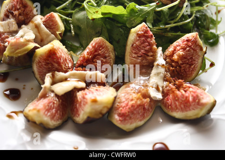 Figues au four avec fromage de chèvre sur salade de roquette noix Banque D'Images