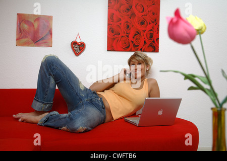 Jeune femme avec un ordinateur portable et téléphone Banque D'Images