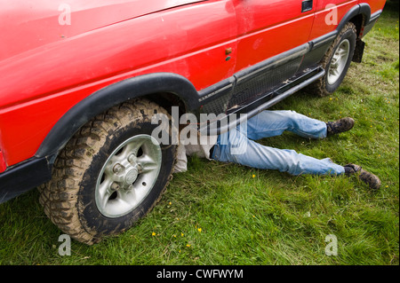 L'homme de travailler sous Land Rover Discovery Land Rover à Eastnor annuel Show Herefordshire Angleterre UK Banque D'Images