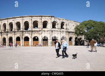 Deux femmes et le chien à pied passé amphithéâtre romain ou arena Nimes France datant d'environ 100annonce montrant voûtes Banque D'Images