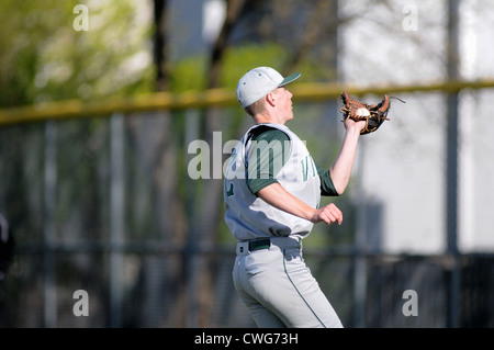 Baseball joueur attrape un pop fly high school jeu. USA. Banque D'Images