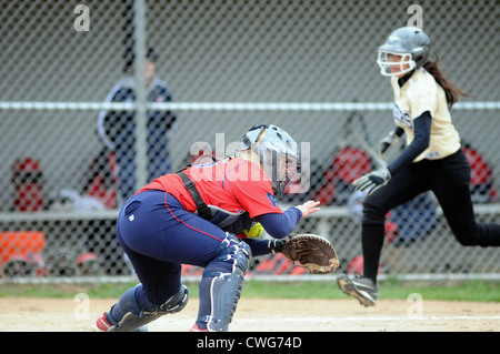 Catcher oublie balle comme une base runner par stries pour marquer. USA. Banque D'Images