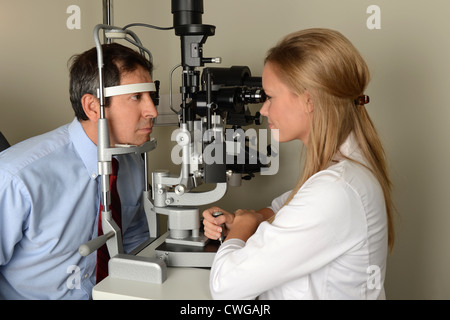 Jeune femme médecin des yeux yeux test de patient en salle d'examen Banque D'Images