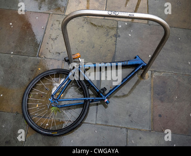 Le châssis et le cadre de la roue avant d'un vélo fixé sur un stand par une manille-type D-lock, le reste ayant été volés. Banque D'Images