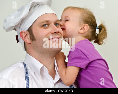 Petite fille et son père s'amusant dans la cuisine Banque D'Images