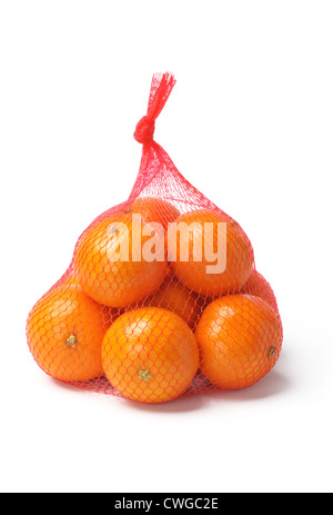 Les oranges fraîches en maille plastique Sac sur fond blanc Banque D'Images