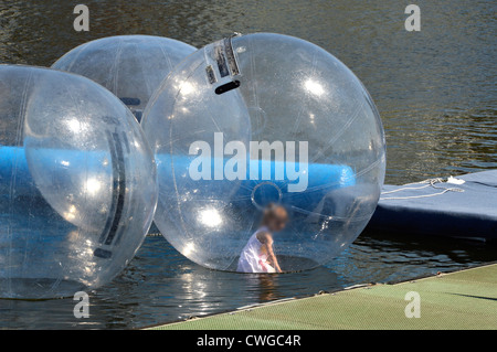 L'intérieur de l'enfant bulle gonflable intégré sur l'eau contenue à l'installation de boules Aqua (face cachée) avec minder (hors du champ) Banque D'Images