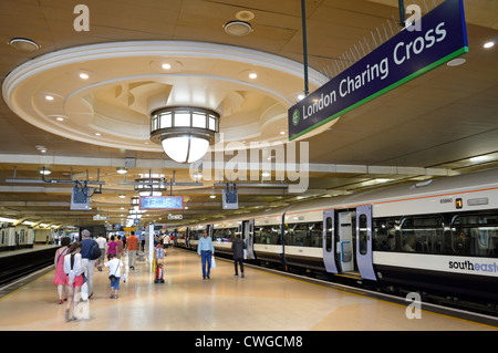 Passagers familiaux et train à la gare de Charing Cross Plate-forme avec grand éclairage décoratif au plafond et panneau Londres Angleterre Royaume-Uni Banque D'Images