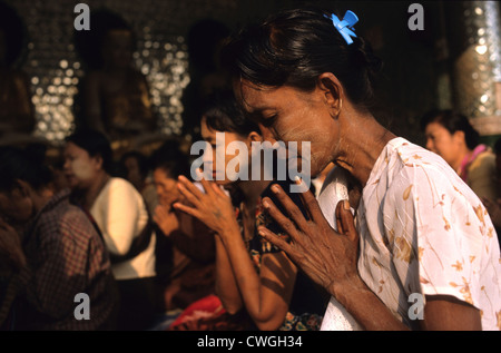 Femme en prière dans la pagode Shwedagon Banque D'Images