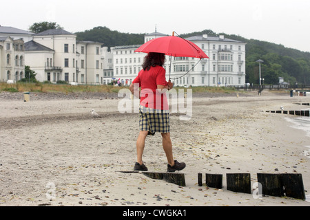 Heiligendamm, femme avec parapluie sur la plage. Dans l'arrière-plan, le Kempinski Grand Hotel Banque D'Images