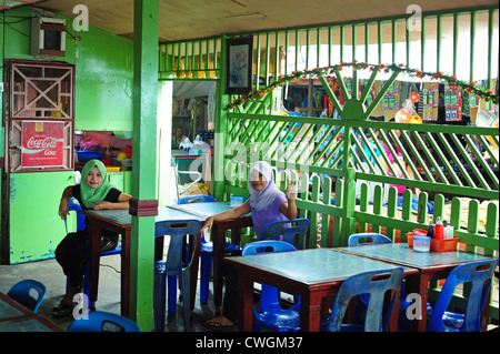 La Malaisie, Bornéo, Semporna, deux femmes voilées dans la pêche restaurant Banque D'Images