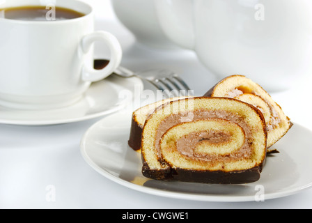 Tranches de rouleau de chocolat sur une assiette et tasse de thé Banque D'Images