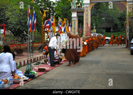 Moines recevant de la nourriture et de vos articles sur le carême bouddhiste Bouddha(jour) sur 12/08/2012 dans le nord-est de la Thaïlande Ubon Ratchathani Banque D'Images