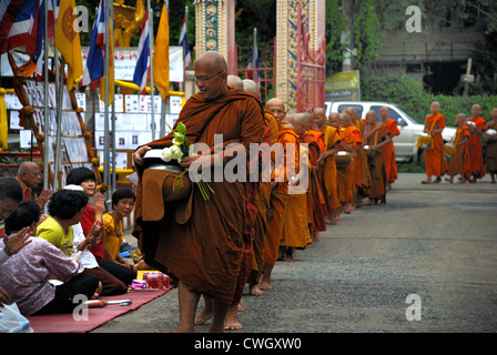 Moines recevant de la nourriture et de vos articles sur le carême bouddhiste Bouddha(jour) sur 12/08/2012 dans le nord-est de la Thaïlande Ubon Ratchathani Banque D'Images