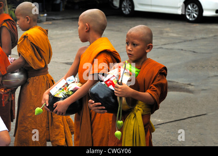 Moines recevant de la nourriture et de vos articles sur le carême bouddhiste Bouddha(jour) sur 12/08/2012 dans le nord-est de la Thaïlande Ubon Ratchathani Banque D'Images