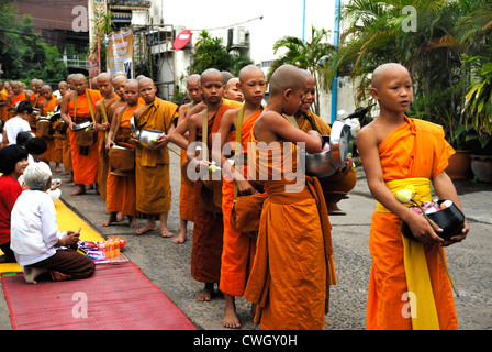 Moines recevant de la nourriture et de vos articles sur le carême bouddhiste Bouddha(jour) sur 12/08/2012 dans le nord-est de la Thaïlande Ubon Ratchathani Banque D'Images