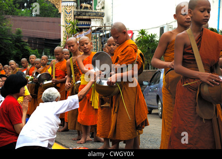 Moines recevant de la nourriture et de vos articles sur le carême bouddhiste Bouddha(jour) sur 12/08/2012 dans le nord-est de la Thaïlande Ubon Ratchathani Banque D'Images