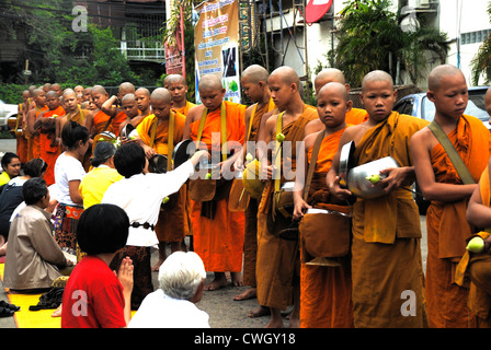 Moines recevant de la nourriture et de vos articles sur le carême bouddhiste Bouddha(jour) sur 12/08/2012 dans le nord-est de la Thaïlande Ubon Ratchathani Banque D'Images